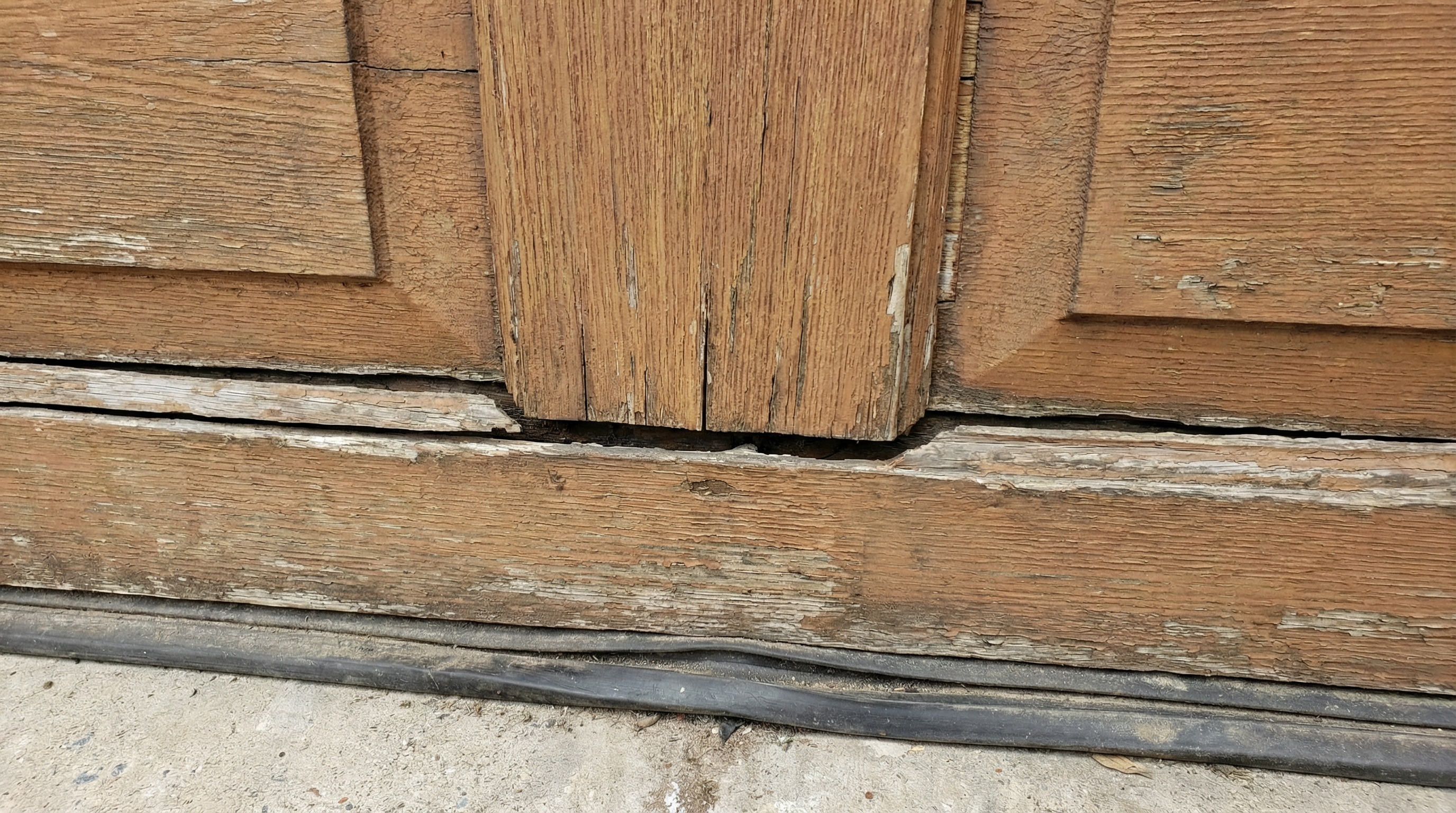 close-up view of uneven garage door gaps and misaligned bottom seal