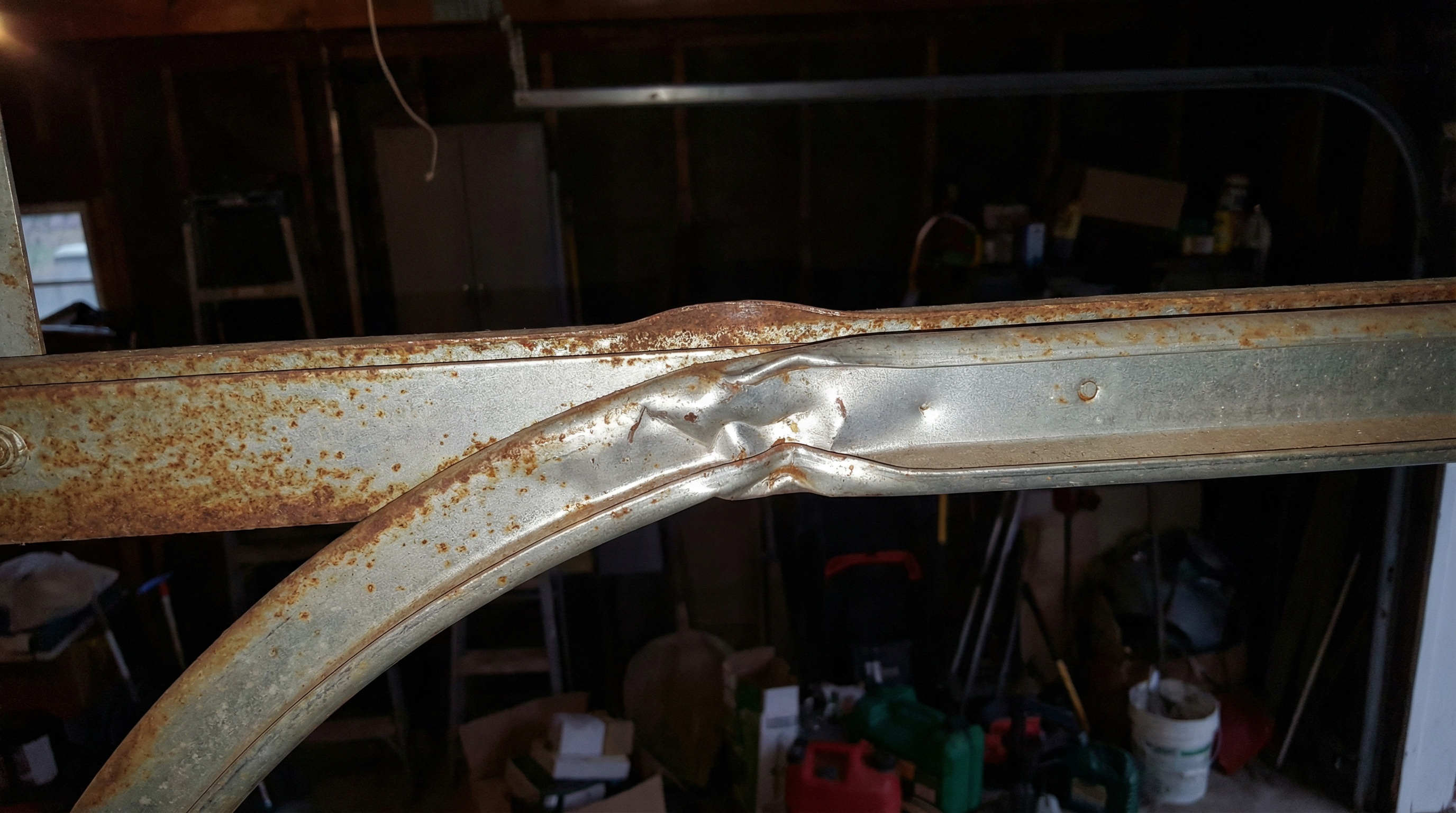 close-up of garage door track showing bent or damaged rail